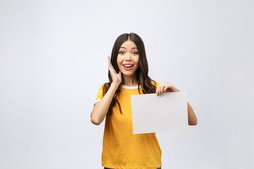 advertising banner sign - woman excited pointing looking down on empty blank billboard paper sign board. Young business woman isolated on white background.