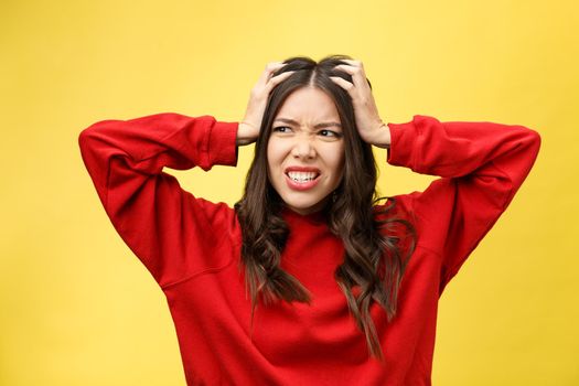 Shocked scared beautiful young woman with mouth widely opened, stares at camera realizes that she disappoint with something, isolated over yellow studio background