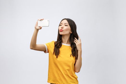 Image of excited happy young woman isolated over grey background make selfie by camera