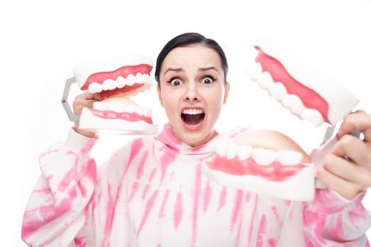 frightened woman holding dental jaw models in her hands. High quality photo