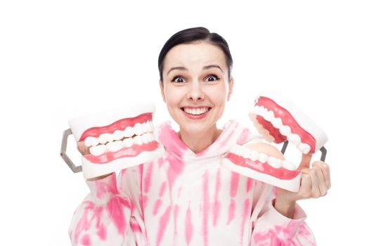 happy woman in pink sweatshirt holding dental mock-ups of the jaw in her hands. High quality photo