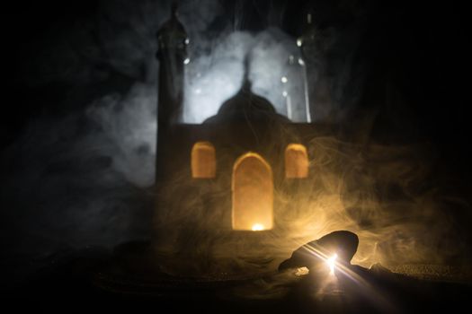 Silhouette of mosque building on toned foggy background. Ramadan Kareem background. Realistic mosque miniature with prayer silhouette. Selective focus