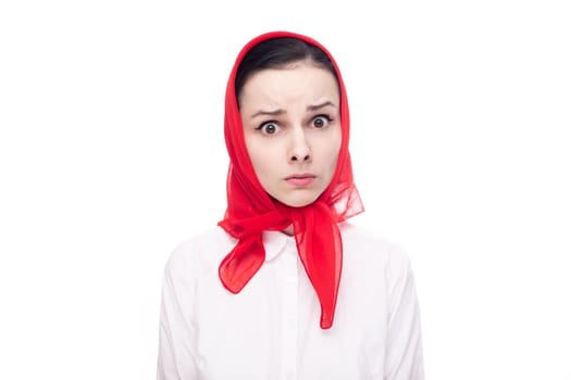 surprised woman in white clothes and a red scarf on her head, white background. High quality photo