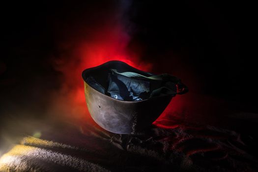 Soviet army Helmet Second World War on sand with backlight and smoke. War concept. Selective focus