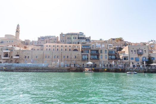 JAFFA OLD CITY, ISRAEL - MAY 10, 2022: View of Old Jaffa Port with beautiful buildings and houses in a sunny day. Panoramic view. High quality photo