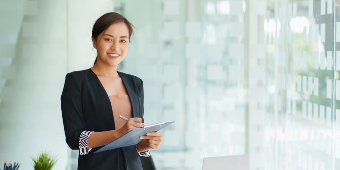 A portrait of Asian happy Businesswoman smiling and working at office