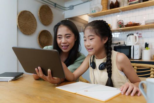 Homeschool Asian mother and little young girl student learning online class. E-learning Online Education concept