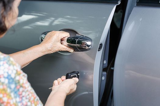 Elderly woman hand open the car on key car alarm systems