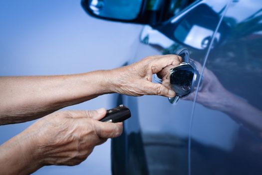 Elderly woman hand open the car on key car alarm systems