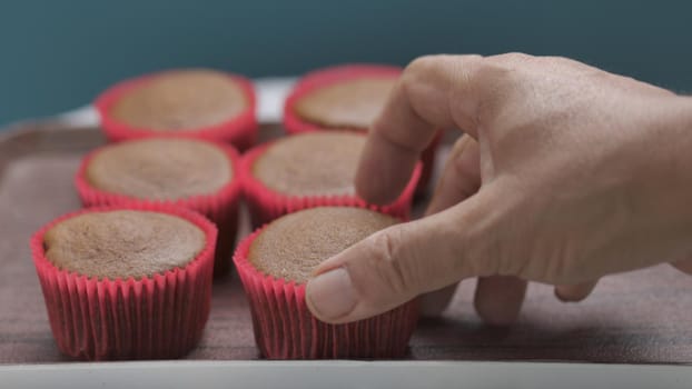 Pick up chocolate cupcakes on table in party.