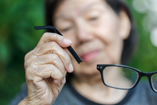 Elderly asian woman repair broken glasses