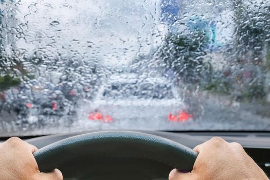 Raindrops on windshield from inside the car in traffic jam