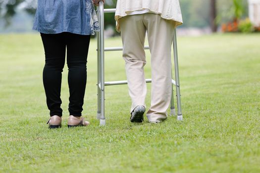 Elderly woman exercise walking in backyard with daughter