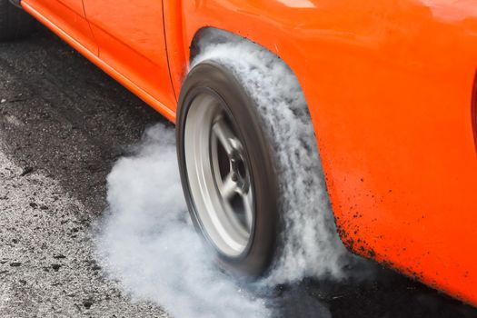 Drag racing car burns rubber off its tires in preparation for the race