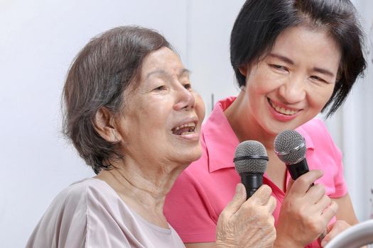 Elderly woman sing a song with daughter at home.