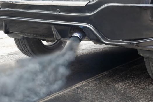 Air pollution from vehicle exhaust pipe on road