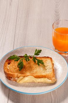Good and delicious food and beverages for breakfast. Toast with butter and cheese on white plate and glass of orange juice.