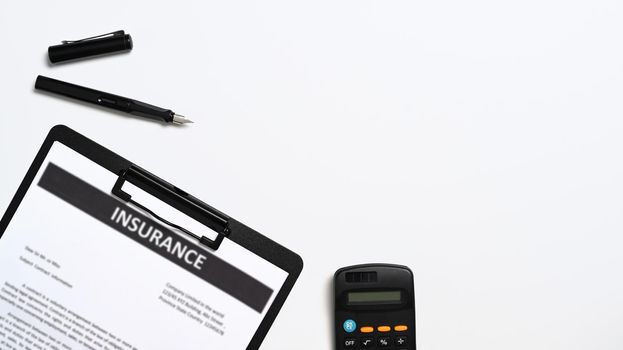 Top view insurance claim form, pen and calculator on white background.