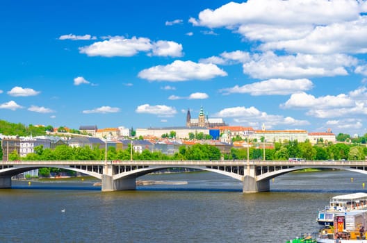 Aerial panoramic view of Prague city, historical center with Prague Castle, St. Vitus Cathedral, Hradcany district, bridges over Vltava river, blue sky white clouds background, Bohemia, Czech Republic