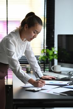 Female accountant or banker calculating tax and salary at office desk. Savings, finances and economy concept.