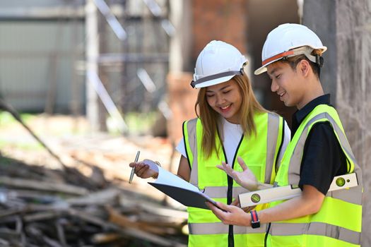 Structural engineer and architect discussing the construction process at construction site.