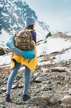 Traveling girl with backpack hiking in the mountains, freedom concept. Hiking people on Asia. Beautiful young woman traveler with a backpack looks at the mountain top before climbing
