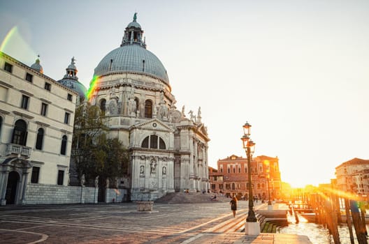 Basilica di Santa Maria della Salute Catholic church on Punta della Dogana on Fondamenta Salute embankment and pier of Grand Canal, Veneto Region, Northern Italy. Sunset view against sun