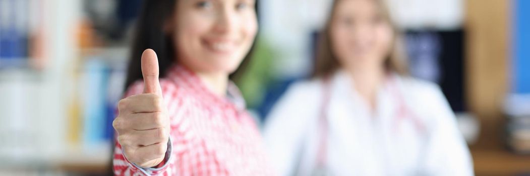 Happy woman in the doctor's office rejoices at recovery, close-up, blurry. Overcoming disease, hope and positive attitude