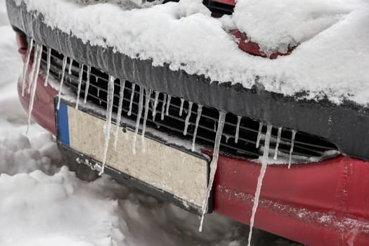 Extreme winter. Car in ice. Icicles on a car close-up.