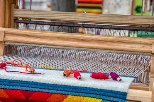 A traditional colorful vintage weaving loom and  thread of yarn.