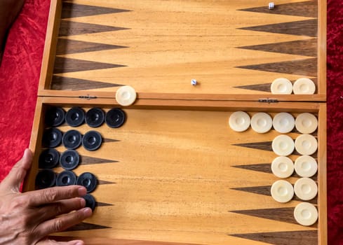 a man moves a checker in a backgammon game