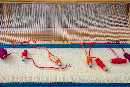 A traditional colorful vintage weaving loom and  thread of yarn.