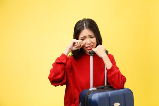 Upset tourist woman in summer casual clothes sit on suitcase put hands on head isolated on yellow orange background. Female traveling abroad to travel on weekends getaway. Air flight journey concept