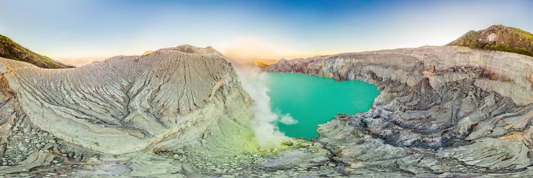 Aerial panoramic shot of the Ijen volcano or Kawah Ijen on the Indonesian language. Famous volcano containing the biggest in the world acid lake and sulfur mining spot at the place where volcanic gasses come from the volcano.