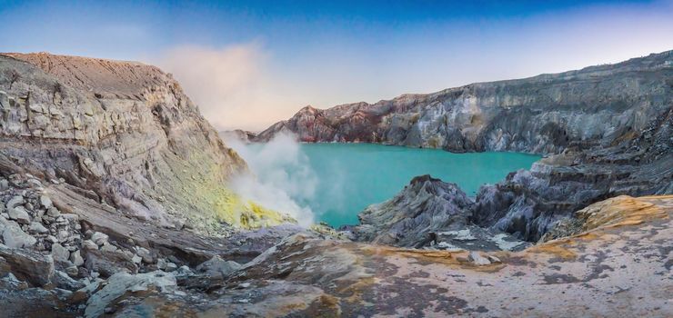 Panoramic shot of the Ijen volcano or Kawah Ijen on the Indonesian language. Famous volcano containing the biggest in the world acid lake and sulfur mining spot at the place where volcanic gasses come from the volcano.