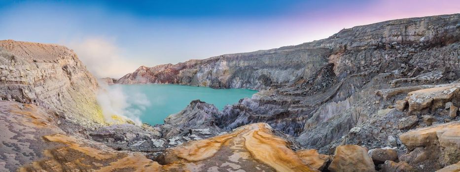 Panoramic shot of the Ijen volcano or Kawah Ijen on the Indonesian language. Famous volcano containing the biggest in the world acid lake and sulfur mining spot at the place where volcanic gasses come from the volcano.