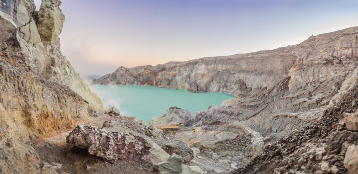 Panoramic shot of the Ijen volcano or Kawah Ijen on the Indonesian language. Famous volcano containing the biggest in the world acid lake and sulfur mining spot at the place where volcanic gasses come from the volcano.