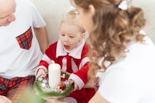 Baby child with hearing aid and cochlear implant having fun with parents in christmas room. Deaf and health