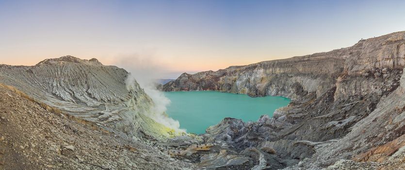 Panoramic shot of the Ijen volcano or Kawah Ijen on the Indonesian language. Famous volcano containing the biggest in the world acid lake and sulfur mining spot at the place where volcanic gasses come from the volcano.