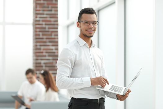 employee typing on a laptop standing in the office. people and technology