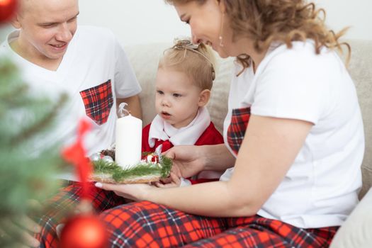 Baby child with hearing aid and cochlear implant having fun with parents in christmas room. Deaf and health