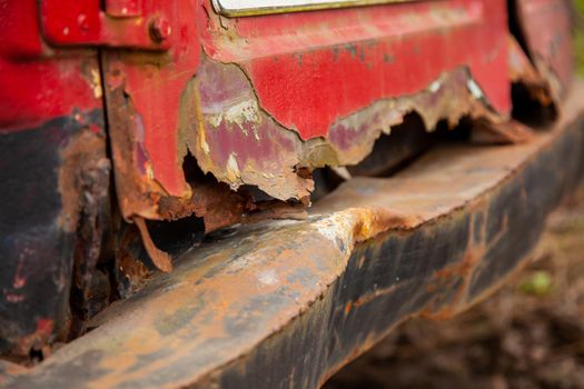 Rusty and bent back of the van. Old rusty bent rear bumper of a car half destroyed by time. Close-up
