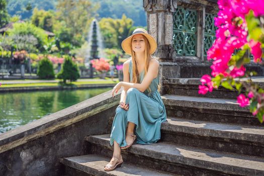 Young woman tourist in Taman Tirtagangga, Water palace, Water park, Bali Indonesia.