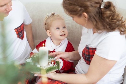 Baby child with hearing aid and cochlear implant having fun with parents in christmas room. Deaf and health