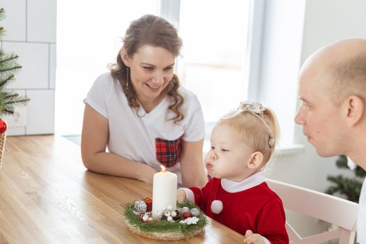 Baby child with hearing aid and cochlear implant having fun with parents in christmas room. Deaf and health