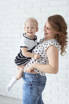 Mother holds her child with hearing aids and cochlear implants . Deaf and health