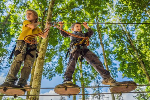 Two little boys in a rope park. Active physical recreation of the child in the fresh air in the park. Training for children.