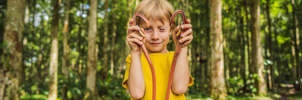 Little boy in a rope park. Active physical recreation of the child in the fresh air in the park. Training for children. BANNER, LONG FORMAT