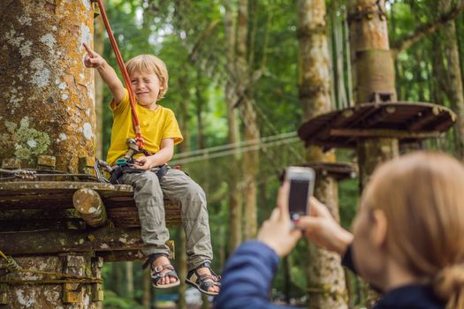 Little boy in a rope park. Active physical recreation of the child in the fresh air in the park. Training for children.