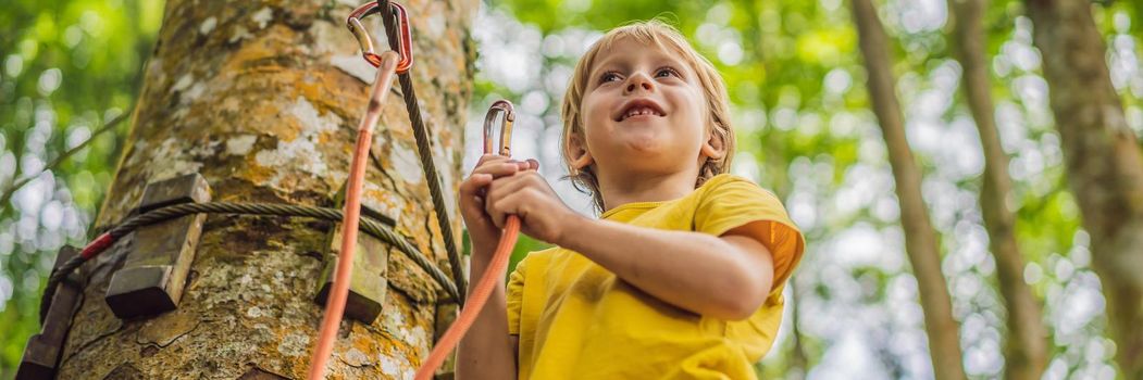 Little boy in a rope park. Active physical recreation of the child in the fresh air in the park. Training for children. BANNER, LONG FORMAT